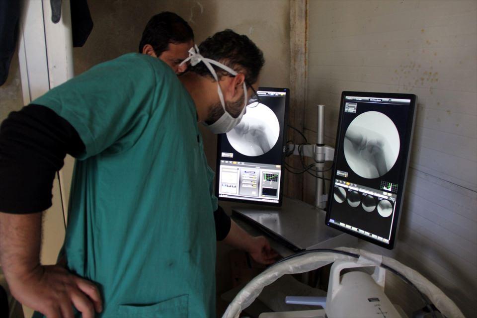 <p>Son 6 ayda yapılan saldırılar nedeniyle 3 kez yer değiştirdiklerini anlatan Musa, "Hastaneyi sınırın sıfır noktasındaki bir çadıra taşıdık. Burada 1 günde 100 yaralıya bakıldı. Ancak buralar da vuruldu. Ambulanslarımız parçalandı. Personelimiz yaralandı. Son çare olarak yer altına hastane açmak zorunda kaldık. Buradaki bir dağı kazdık, üstünde ağaçlarla tahkimatını yaptık. Bu şekilde hem sığınak hem de hastane oldu." diye konuştu.</p>
<p> </p>