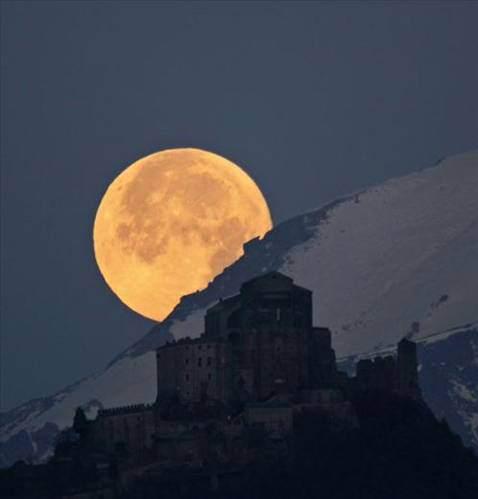 Arkada dolunay, önde Alpler ve Pirchiriano dağının 1000 metrelik yükseltisine kurulmuş Sacra di San Michele manastırı… İnsani, jeolojik ve astronomik zaman ölçüleri bu fotoğrafta yan yana gelmiş. Fotoğraftaki bina insan zamanıyla eski olabilir ama dünya zamanıyla yanındaki dağlara göre daha bir bebek. Ay ise milyarlarca yıldır hep aynı.