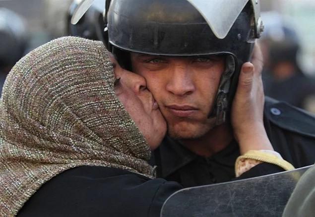 <p>Mısırlı bir kadın, olaylarda halka saldırmayı reddeden bir polisi anne şefkatiyle öperken yakalanan bu fotoğraf tarihe geçecek karelerden biri olarak hafızamıza kazınıyor. (2011)</p>
