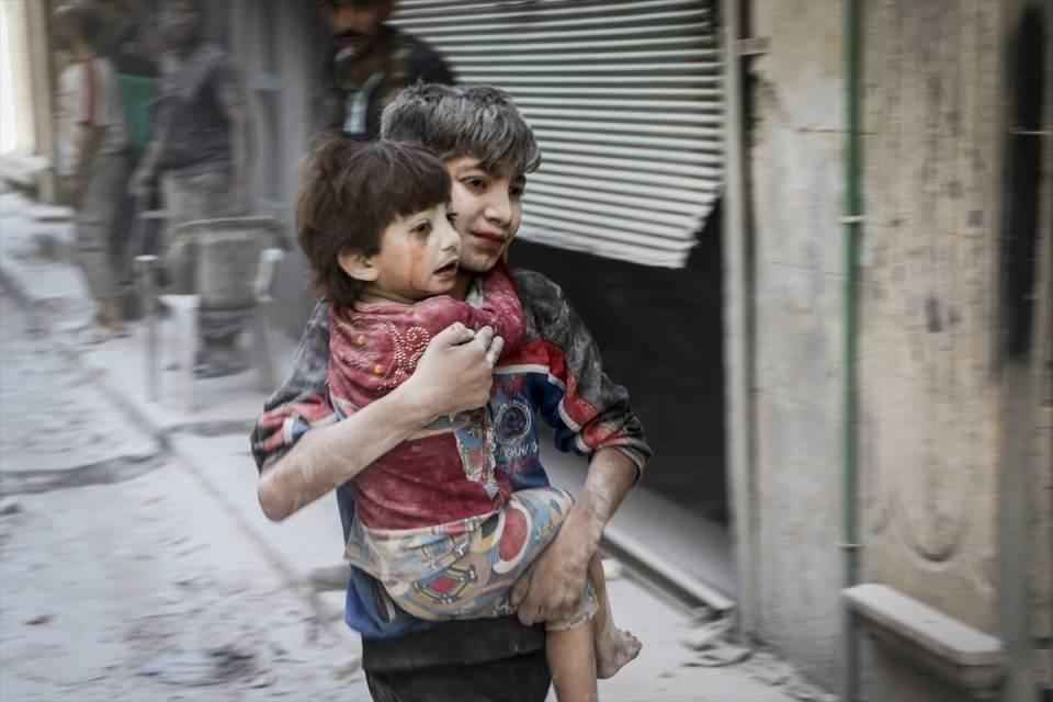 <p>Rus ordusuna ait savaş uçağı, Halep'te muhaliflerin denetimindeki Salihiyin semtinde yerleşim yerini bombaladı. Saldırıdan etkilenen bir çocuk, kucağında taşıdığı kardeşiyle birlikte bölgeden uzaklaştı. </p>