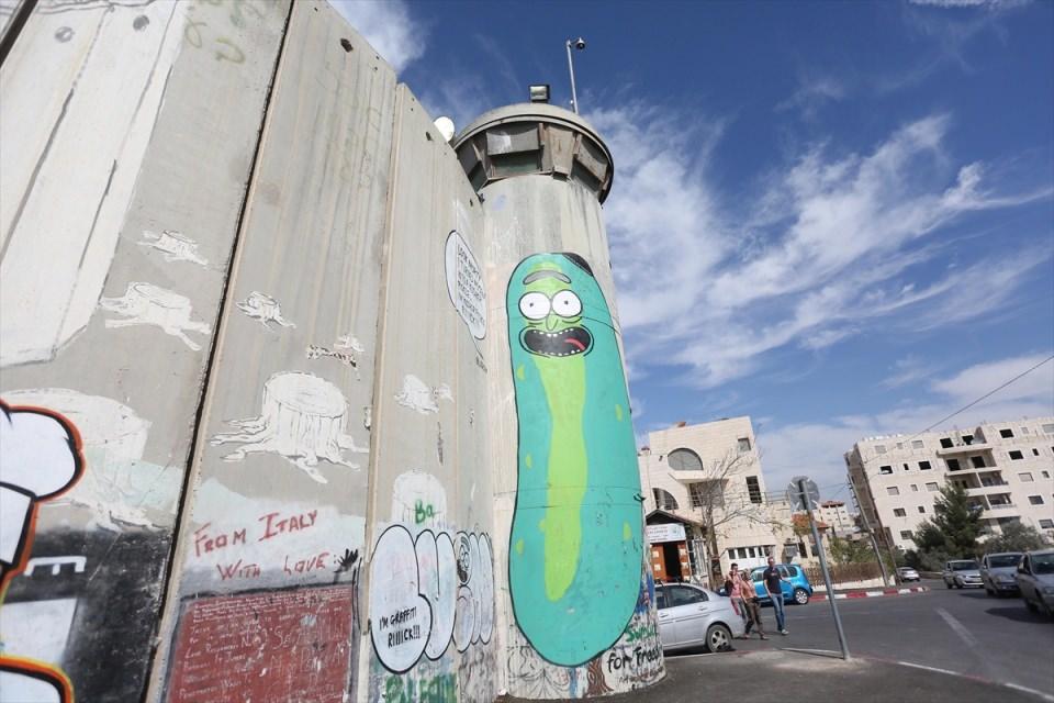 <p>Duvardaki bir başka grafiti de ise Trump'ın Yahudilerin başlarındaki dini sembolleri Kipayı taktığı ve ayrım duvarına, "Sana kardeş inşa edeceğim" (ABD ile Meksika arasına yapılması düşünülen duvar) dediği görülüyor.</p>
<p> </p>