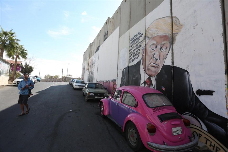 <p>Kent sakinleri her gün farklı uyruklara sahip sanatçıların duvara çizdikleri yeni grafitilerle sabaha uyanıyor. Avustralyalı grafiti sanatçısı Lushsux'un geçen pazar gecesi İsrail Başbakanı Binyamin Netanyahu ile ABD Başkanı Donald Trump'ın birbirlerini öptüğü grafitisi, bu protesto eylemlerinden sadece biri.</p>

<p> </p>
