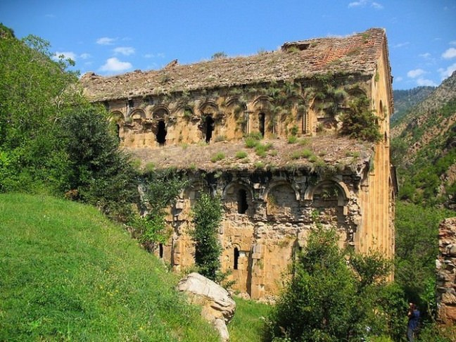 <p>Barhal (Altıparmak) Kilisesi<br />
Yusufeli ilçesi Sarıgöl bucağı Altıparmak köyündedir. Kilise, 9 ncu Y.Y.da Kral David Magistros zamanında yapılarak Vaftizci Yahya‘ya adandığı yazılı kaynaklardan anlaşılmaktadır. 1677 yılında Hacı Şerif Efendi tarafından onartılarak camiye çevrilmiştir. Kilise, yontma taş ve kesme taştan yapılan kiremitlerden çatısı bağlanmış harçsız bir zemine dayanmadan “Lambalı” denilen planda yapılmıştır. Yapı, dıştan 28.40 x 18.65 cm. boyutlarında, üç nefli bazilikaldir. Gri renkli düzgün kesilmiş taşlarla örtülmüş cepheler güney ve kuzeyde eş boyutlu, doğu ve batıda ortadan yanlara doğru açılan köre kemerlerle hareketlendirilmiştir. Pencere üstündeki alçak kabartma tekniğinde yapılmış bitkisel figürlü süslemeler iyi durumdadır. Yusufeli ilçesinden 30 km.lik yolla gidilmektedir.</p>
