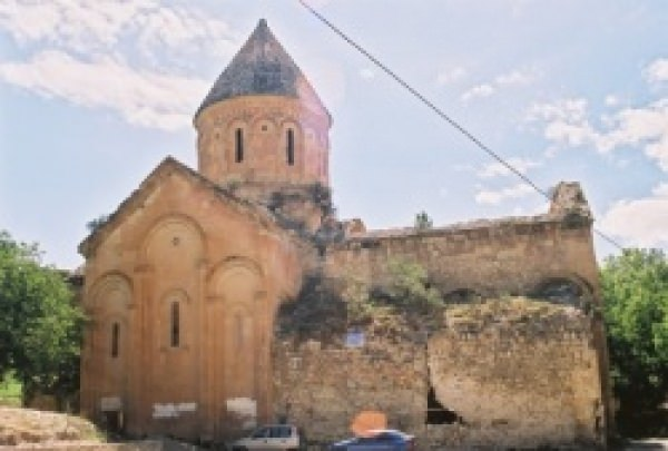 <p>İşhan Manastır Kilisesi<br />
Yusufeli ilçesine bağlı İşhan köyü içerisindedir. Kiliseye Oltu güzergahı üzerinden Artvin – Erzurum bağlantılı Devlet Karayolunun 92. km.sinden kuzey yönüne ayrılan 7 km.lik yol ile gidilmektedir. 951 tarihli el yazmasına göre Kilise; Rahip Khandza’nın (759 – 861) yeğeni ve öğrencisi Rahip Seba tarafından, Kral Andernese’nin desteği ve maddi katkısı ile yaptırılmıştır. Manastırın yapımına 955 yılında Gürcü Kralı David zamanında başlanmış 1027 yılında Bagratlı Kralı Magistros tarafından bitirilmiştir. Güneybatıda Meryem Ana Şapeli bulunmaktadır. 35 m. uzunluğunda 20.75 cm. genişliğinde olan yapı, kubbeli bazilikal plan tipindedir.</p>
