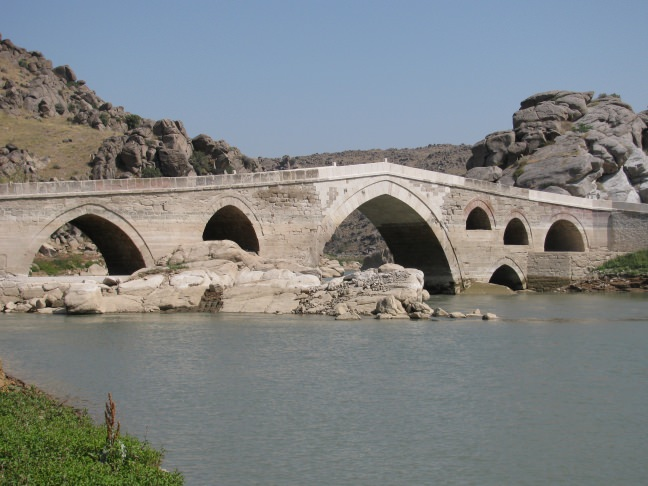 <p><strong>Çeşnigir Köprüsü</strong></p>

<p>Selçuklu dönemi eserlerinden biri olan Çeşnigir Köprüsü, Kırıkkale ilçelerinden biri olan Karakeçili ilçesine bağlı Köprüköy beldesinde bulunmaktadır. Çeşnigir Köprüsü hakkında çok fazla bilgi yoktur. Yapılan mimari incelemelerde 13. yüzyıl dönemine ait olduğu anlaşılmıştır. Köprü ile ilgili kesin bilinen tek şey, Yavuz Sultan Selim’in Mısır seferine giderken köprüyü tekrar yaptırmış olmasıdır. Çeşnigir Köprüsü 1898 yılına kadar araç trafiğine açıktı. Fakat Kapulukaya Barajı’nın yapımından sonra araç trafiğine kapatılmıştır.</p>
