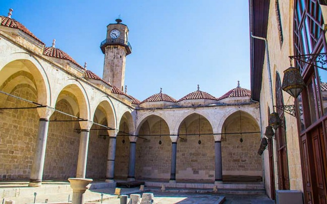 <p><strong>Tarsus Ulu Camii</strong></p>

<p>Tarsus Ulu Camii, 1579 yılında 1579’de Ramazanoğlu beyi Piri Mehmet Paşa’nın oğlu İbrahim Bey tarafından yaptırılmış. Kentin en eski ve geçmişte merkezi olan bölgesinde bulunan cami, etrafındaki türbe ve imaret ile 1895’de eklenen saat kulesi ile büyük bir külliye görünümünü koruyor.</p>

<p>Cami-i Kebir ya da Cami-i Nur diye adlandırılan caminin bitişiğindeki türbede Hz. Şit, Hz. Lokman Hekim ve Halife Me’mun’un mezar odaları bulunuyor.</p>
