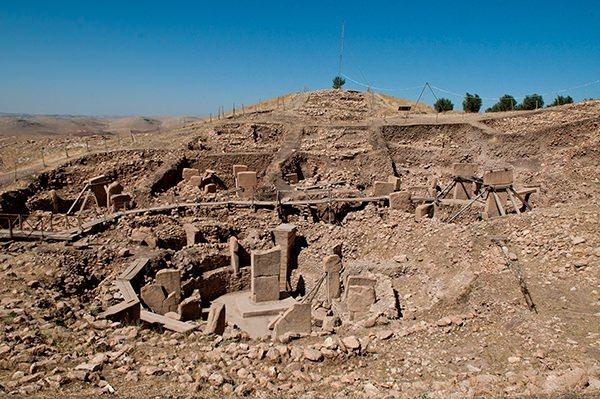 <p>Göbekli Tepe</p>

<p>Göbeklitepe, Şanlıurfa’nın Örencik Köyü yakınlarında yer alan dünyanın bilinen en eski kült yapılar topluluğudur. Bu yapıların ortak özelliği, T biçimindeki 10 – 12 dikilitaş yuvarlak planda dizilmiş, araları taş duvarla örülmüştür. Bu yapının merkezinde daha yüksek boyda iki dikilitaş karşılıklı olarak yerleştirilmiştir. Bu dikilitaşların çoğu üzerinde insan, el ve kol, çeşitli hayvan ve soyut semboller, kabartma ya da oyularak betimlenmiştir. Söz konusu motifler yer yer bir süsleme olamayacak kadar yoğun olarak kullanılmıştır. Bu kompozisyonun, bir öykü, bir anlatım ya da bir mesaj ifade ettiği düşünülmektedir. Tüm bunlar ve kazılarda ortaya çıkarılan anıtsal mimari, Göbekli Tepe’yi eşsiz ve özel yapmaktadır. Bu bağlamda UNESCO tarafından 15.04.2011 tarihinde Dünya Mirasları’na aday gösterilmiştir.</p>
