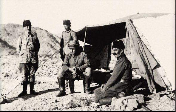 <p>Yenbû’l-Nahl harekatında komutanlık çadırı önünde, Fahreddin Paşa cephane sandığı üzerinde otururken, Yarbay Ali Necip Bey solunda, Kurmay başkan Yarbay Kadri sağında ayakta, Yüzbaşı Tahsin Kadri Efendi ise daha geride.</p>