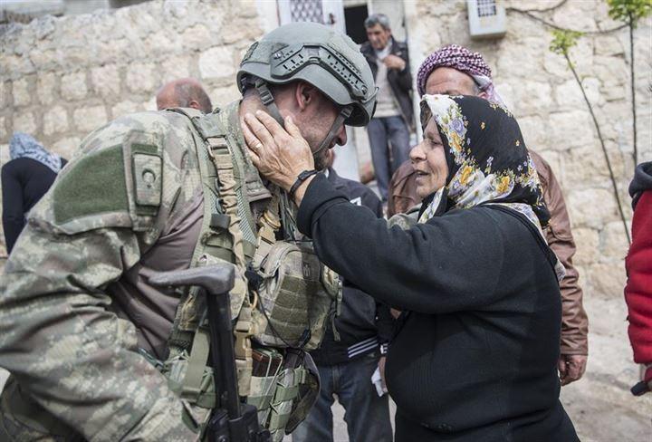 <p>Zeytin Dalı Harekatıyla teröristlerden temizlenen Afrin’de halk yeniden güvenli günlere kavuşmanın mutluluğunu yaşıyor. Teröristlerin olduğu dönemde çocuklarının zorla silah altına alınmak istendiğini, kendilerinden para toplandığını ve ilçeyi terk etmelerine izin verilmediğini anlatan Afrinliler, Türk askerini görünce mutluluklarını göstermek için kurban kestiklerini söyledi. Afrin'de Kafer Çil Mahallesi'nde yaşayan 60 yaşındaki Melek Salih (sağda), bir askere sarılarak sevgi gösterisinde bulundu.</p>
