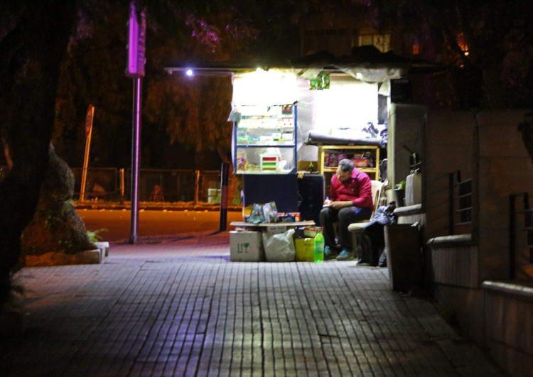 <p>Bir Suriyeli esnaf, g&uuml;n&uuml;n ilk ışıklarıyla birlikte d&uuml;kkanının &ouml;n&uuml;nde oturup not alırken AFP objektiflerine b&ouml;yle yansıdı</p>
