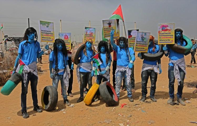 <p>Gazze'nin Han Yunus kentin doğusundaki İsrail sınırında Avatar filmindeki Na'vi ırkının kıyafetler ve makyajlarıyla maviye bürünen bir grup Filistinli, İsrail karşıtı sloganlar atarak İsrail'in Filistinlilere yönelik ihlalleri protesto etti.</p>
