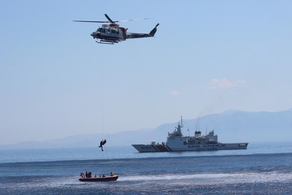 <p>Tatbikatın birinci aşamasında, senaryo gereği Türk Arama Kurtarma Bölgesi içerisinde Ege Denizi’nin uluslararası sularında, içerisinde göçmenlerin bulunduğu kuru yük gemisinden tehlike sinyali alınması ve geminin su aldığının öğrenilmesi üzerine kazazedelere yönelik arama ve kurtarma faaliyeti icra edildi. </p>
