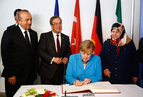 <p>Merkel, kurbanlar için açılan deftere yazdı.</p>