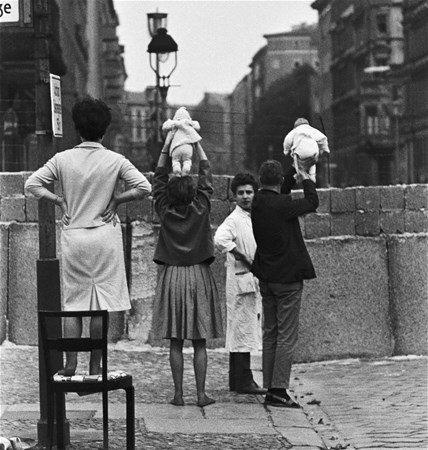 <p>Berlin Duvarı'nın diğer tarafında kalan akrabalarına göstermek için bebeklerini yukarıya kaldıran çift, 1961. </p>
<p> </p>