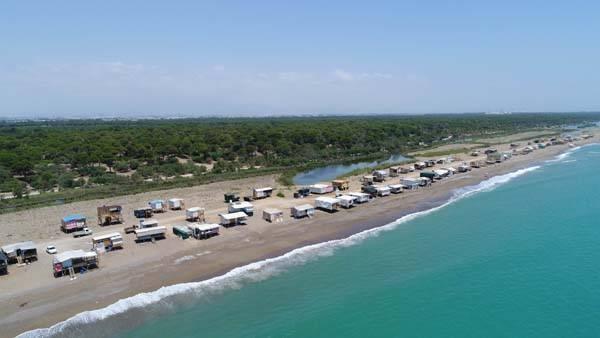 <p>Antalya'da 5 yıldızlı otellerin yoğun bulunduğu b&ouml;lgenin hemen yanında yer alan Kumk&ouml;y Mahallesi'nde denize sıfır oba ve &ccedil;ardaklar dikkati &ccedil;ekiyor. Aksu ve Serik il&ccedil;elerinden gelen onlarca kişi, serinlemek amacıyla sahilde kendi &ccedil;abalarıyla yaptıkları derme &ccedil;atma yerlerde yaz mevsimini ge&ccedil;iriyor. Yaşlılar, kadınlar ve &ccedil;ocuklar g&uuml;n&uuml;n 24 saatini burada ge&ccedil;irirken, işi olanlar g&uuml;nd&uuml;z saatlerinde ayrılıp akşam yeniden d&ouml;n&uuml;yor.</p>

<p>&nbsp;</p>
