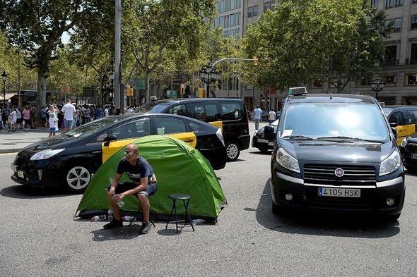 <p>Şehir merkezindeki Gran Via Caddesi'ni trafiğe kapatan yaklaşık 400 taksici, geceyi arabalarında ya da kurdukları çadırda geçirdi.</p>
