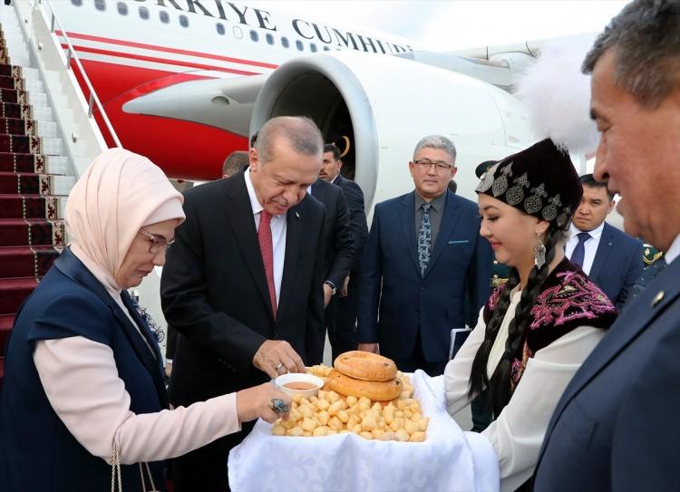 <p>Erdoğan ve eşi Emine Erdoğan'a, uçaktan inişlerinde kendilerini karşılayan yöresel kıyafetli iki Kırgız genç kız çiçek takdim ederken, geleneksel Kırgız hamur işi "Borsok" ve bal ikramı yaptı.</p>
