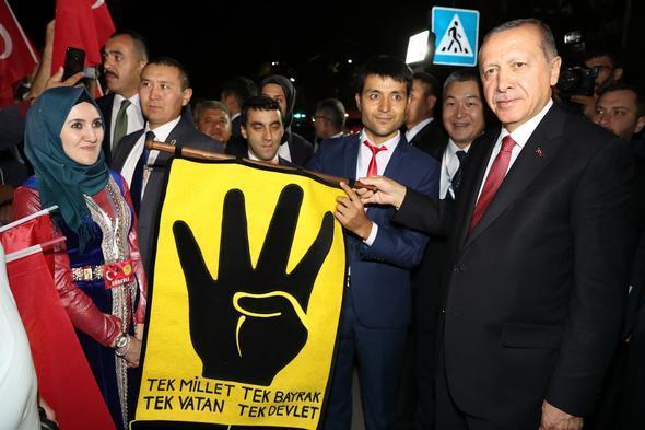 <p>Ellerinde, Türk ve Kırgız bayrakları taşıyan gruptakiler, "Dik duran Erdoğan" sloganı attı.</p>
<p> </p>