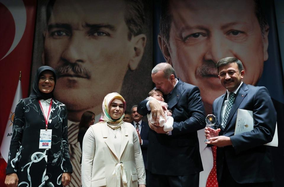 <p>Erdoğan, konuşmasının ardından AK Parti Siyaset Akademisi'nde başarılı olan kursiyerlere plaket verdi. Ankara İl Teşkilatından Seda Altundağ, ödülünü almaya 40 günlük bebeği ile gedi. Erdoğan, bebeği sevdi.</p>
