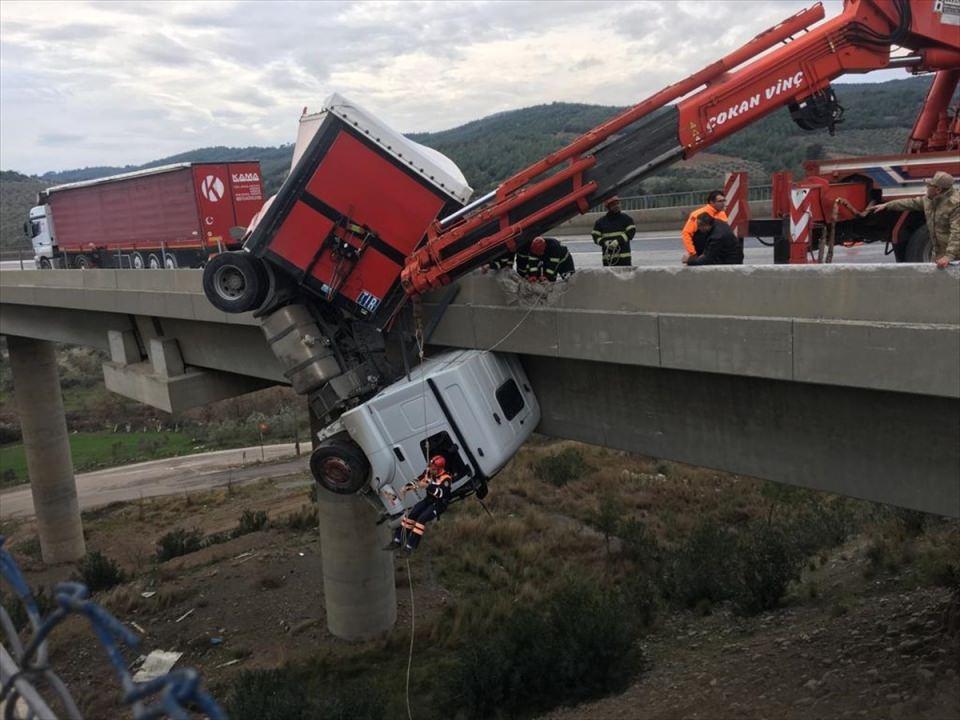 <p>Asılı kalan tır, olay yerine gelen iki vinç yardımıya uzun uğraşlar sonucu kurtarılabildi</p>