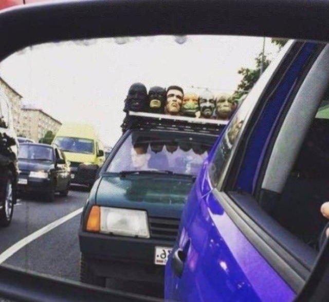 <p>Arabayı dekoratif  şekilde oyuncak kafalarla süsleyen bir adam</p>
