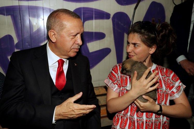 <p>Erdoğan, kucağındaki yavru köpekle yanına oturan bir gençle sohbet etti.</p>
<p> </p>