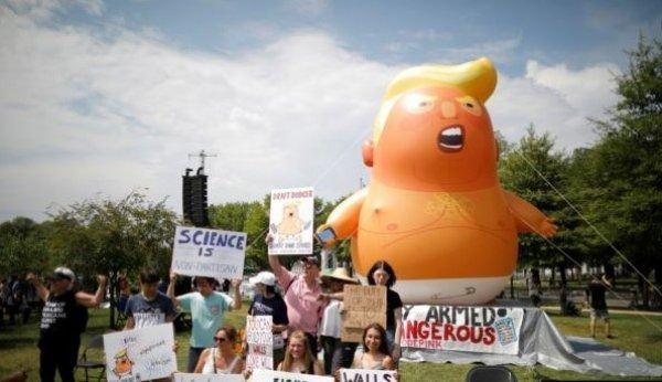 <p>Washington polisinin helyum doldurularak uçurulmasına müsaade etmediği dev balon, yere bağlı şekilde göstericilerin eylemine eşlik etti.</p>