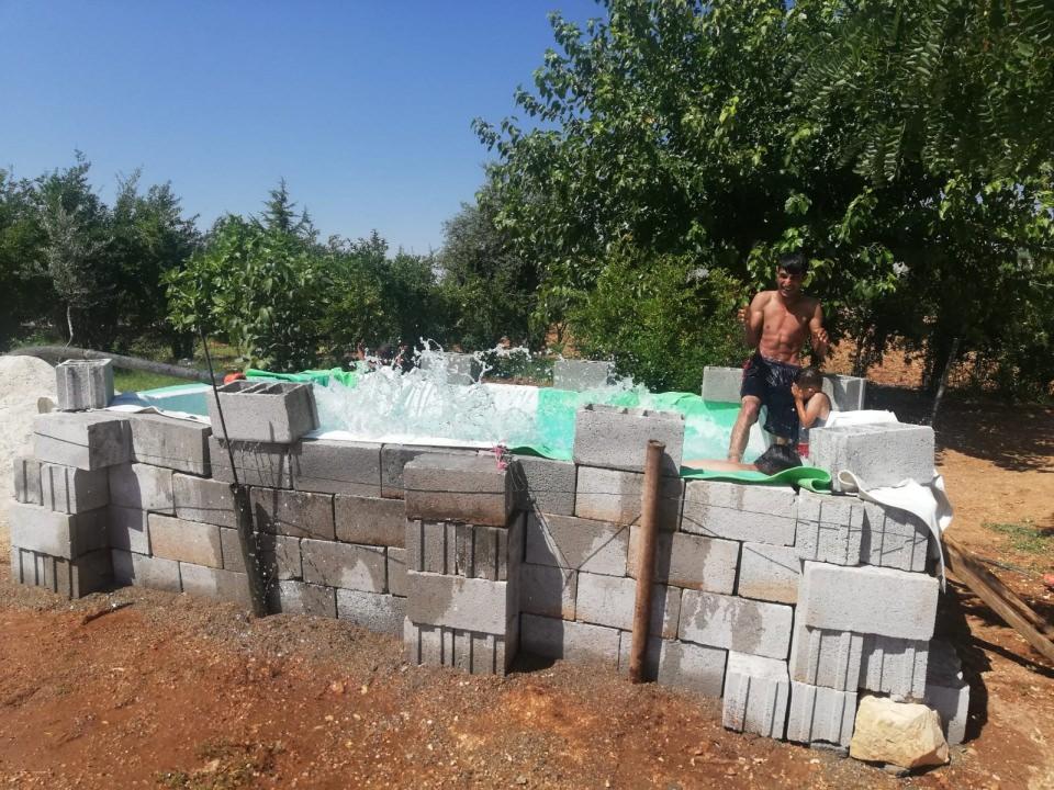 <p>Mardin’in Yeşilli ilçesine bağlı Zeytinli köyünde yaşayan 8 çocuk babası Serhan Cebeci, 45 dereceyi bulan sıcaklardan bunalan çocukları için ilginç bir çözüm geliştirdi.</p>
