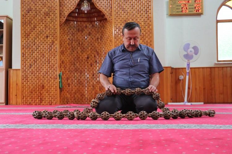 <p><strong>Daha sonra ikinci tespihi yapmaya başladığını anlatan Maden, şöyle devam etti:</strong></p>
<p>"Aylarca emek verdim. Burada en öne çıkan şey, sabır. Bunu tek parça ağaçtan çivi, tutkal, ip kullanmadan yaptım. İmamenin üzerine Kabe'nin maketini çıkarttım. Tespihin boyu 185 santimetre. Tanelerin içindeki topları deliklerden oyarak yaptım. Tespihe çok emek verdim."</p>
