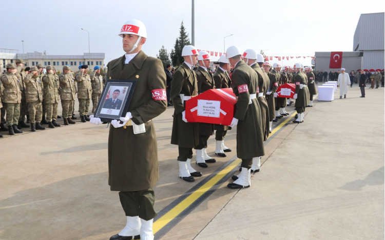 <p>Şehitlerin Türk bayrağına sarılı tabutları, askerler tarafından omuzlanarak uçak ve helikopterlere konuldu.</p>
