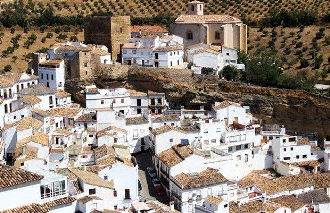 <p>Devasa bir kayalığın altında yer alan Setenil de las Bodegas, bu y&ouml;n&uuml;yle turistlerin akınına uğruyor. Kayalığın altına inşa edilmiş evler Setenil de las Bodegas'ın en dikkat &ccedil;ekici y&ouml;n&uuml;.</p>
