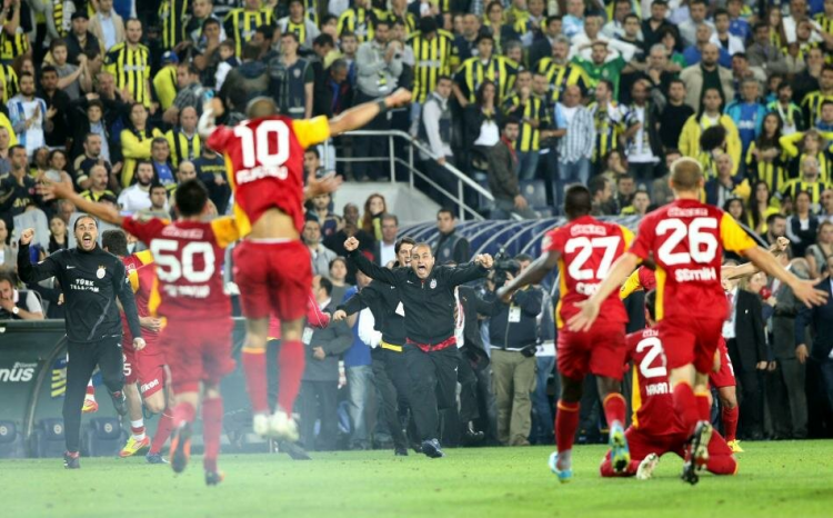 <p><span style="color:#FFD700"><strong>KADIKÖY'DE GALATASARAY'IN ŞAMPİYONLUĞU</strong></span></p>
<p>12.05.2012</p>
<p>Ezeli rekabetin tarihinde belki de en çok konuşulan maçlardan biri Galatasaray'ın Şükrü Saracoğlu Stadı'ndaki şampiyonluk ilanı oldu. Sarı kırmızılı takım Dia ve Ujfalusi'nin atıldığı Süper Final'in son maçında Fenerbahçe ile 0-0 berabere kalarak şampiyonluğunu ilan etmişti</p>