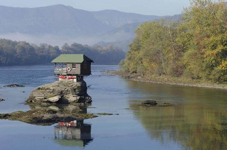 <p>Drina Nehri'nin ortasında, sessiz ve yalnız bir ahşap kulübe, dünyanın dört bir yanındaki gezginlerin ortak ziyaret noktası haline geldi. Sırbistan'ın sert havasına ve nehrin hırçın sularına dayanarak 45 yıldır ayakta kalan bu minik evi dünyaya duyuran isimse ünlü Macar fotoğrafçı Irene Becker… Becker çektiği fotoğrafla ilginç evi gün ışığına çıkarttı. Fotoğraf "Bajina Basta kasabasının yakınında, Drina Nehri'nin ortasında bir ev" adıyla, National Geographic sitesinde günün fotoğrafı seçilince, tek gözlü kulübe dünya çapında bir üne kavuştu.</p>
<p> </p>