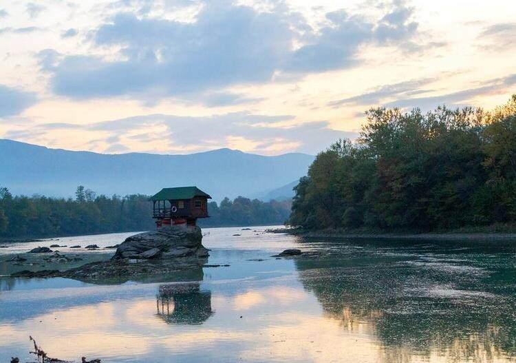 <p>Dünya henüz bu şirin kulübeyi kısa bir süredir tanısa da yerel halk tarafından 45 yıldır bilinen evin yapılış hikâyesi de hayli ilginç. Tara Ulusal Parkı'nın doğu ucundaki bir vadide bulunan Bajina Basta kasabasının yakınındaki ev, 1968'de birkaç gencin el emeğiyle inşa edilmiş. Evin şimdiki sahibi Mili Mandic, o dönemde hırçın bir nehrin ortasına, ufak da olsa bir kulübe inşa etmenin zor bir iş olduğunu, fakat arkadaşlarının yardımı sayesinde bu işin altından kalkmayı başardıklarını söylüyor.</p>