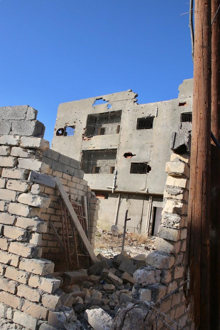 <p>Yol kenarları devrilmiş, yanmış ya da kurşun ve şarapnel darbeleriyle hurda halini almış arabalarla dolu. Mahallenin iç kısımlarına ilerledikçe yıkım daha da artıyor bazı binaların, dış cephelerinin tamamen çökmesi dikkati çekiyor. </p>
<p> </p>