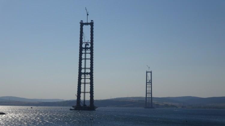 <p>1915 Çanakkale Köprüsü’nün Cumhuriyet’in kuruluşunun 100’üncü yılını temsilen orta açıklığının 2023 metre olması planlanıyor. Bu açıklık, dünyanın en yüksek kuleler arası açıklığa sahip asma köprü olması özelliğini taşıyor. Köprü hizmete açıldıktan sonra iki yaka arasındaki ulaşım mesafesi 6 dakikaya inecek. Köprünün bölgeye de ciddi faydalar sağlayacağı ve özellikle Lapseki’ye yatırımcı talebinin artacağı öngörülüyor.</p>