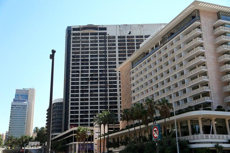 <p>Holiday Inn'in yanında ileriki yılllarda inşa edilen diğer parıltılı oteller ise Beyrut Limanı'ndaki korkunç patlamanın ardından kırık camları, dışa taşan perdeleri ve hasar görmüş halleriyle yeni bir faciayı anlatıyor.</p>
<p> </p>