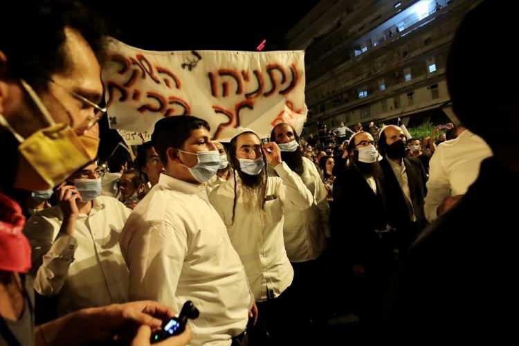 <p>Siyah ve kırmızı renkte bayraklar taşıyan göstericilerden bazıları İsrail Başbakanı'nı kastederek "suç başbakanı" yazılı tişörtler giydi, sık sık "Yalancı Netanyahu evine dön" sloganı attı.</p>
