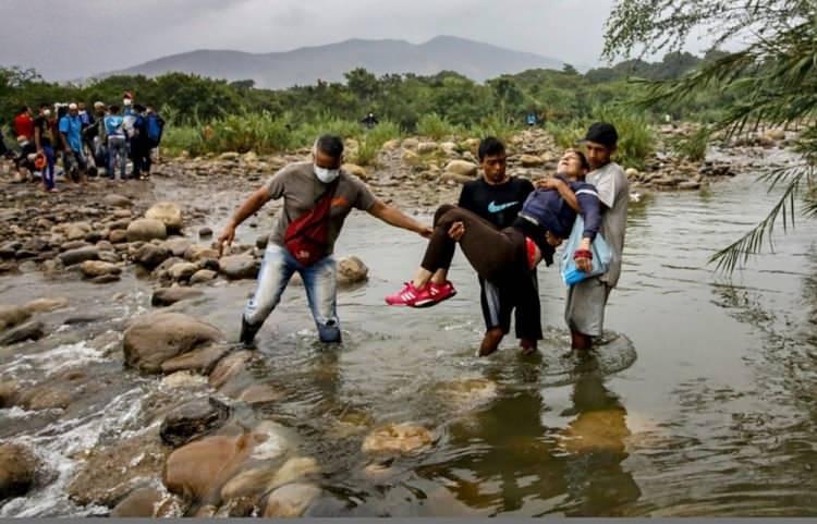 <p>Baygın bir kadını Kolombiya sınırında i&ccedil;eri sokmaya &ccedil;alışan Venezulalılar</p>

