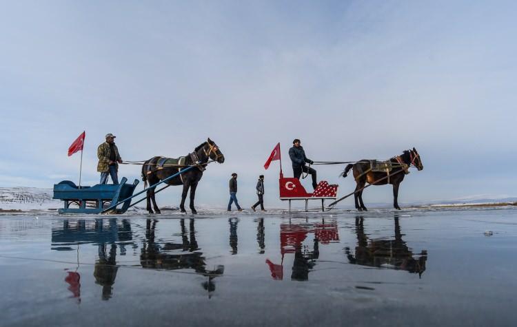 <p>Yüzeyinin bir kısmı donan Çıldır Gölü'nde, atlı kızakçılar, kar yağmadığı için cam gibi altındaki balıkların ve yosunların gözüktüğü buzun üzerinde ziyaretçilerine gezinti yaptırıyor.</p>
