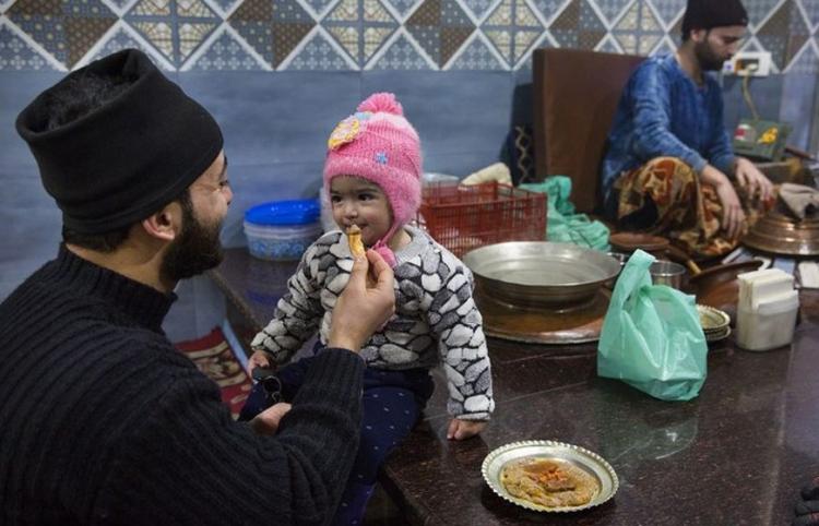 <p>Hindistan kontrolündeki Keşmir'in yazlık başkenti Srinagar'daki bir dükkanda bir adam, bir çocuğa "Harisa" yediriyor.</p>
