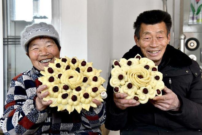 <p>Çin'in doğusundaki Shandong eyaletine bağlı Juancheng ilçesinin sakinlerinden Chen Baicang (sağda) ve eşi kırmızı hurma ile süslenmiş Huagao keklerini gösteriyor.</p>
