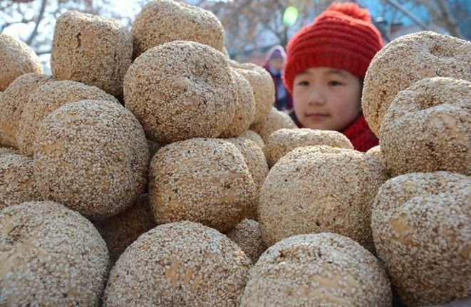 <p>Çin'in doğusundaki Shandong eyaletine bağlı Yiyuan ilçesinde bir çocuk malt şeker, pirinç unu hamuru ve susamdan yapılan bir Çin Yeni Yılı atıştırmalığı olan "Şekerli Kavun" satın alıyor.</p>
