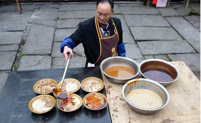 <p>Çin'in güneybatısındaki Sichuan eyaletindeki Yingjing ilçesinde bir aşçı Çin Yeni Yılı öncesi "Bang Bang Tavuğu" adı verilen terbiye edilmiş tavuk etinden yerel bir yemek hazırlıyor.</p>
