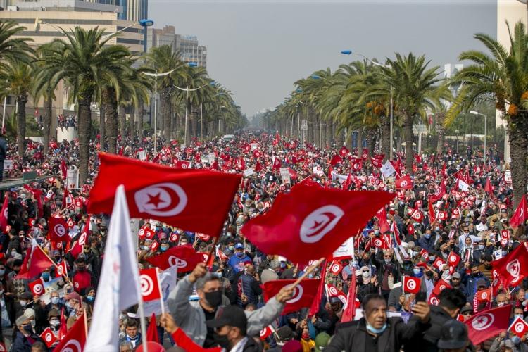 <p>Nahda Hareketi, "ulusal birliğin güçlendirilmesi ve diyaloğun gerekliliği" mesajını vermek için düzenleyecekleri yürüyüşe geniş katılım çağrısında bulunmuştu. Tunus Meclis Başkanı ve Nahda Hareketi lideri Raşid el-Gannuşi, Cumhurbaşkanı Said ile Başbakan Meşişi arasındaki kabine revizyonu krizinin çözümü için 20 Şubat'ta üçlü toplantı önerisinde bulunmuştu.</p>
