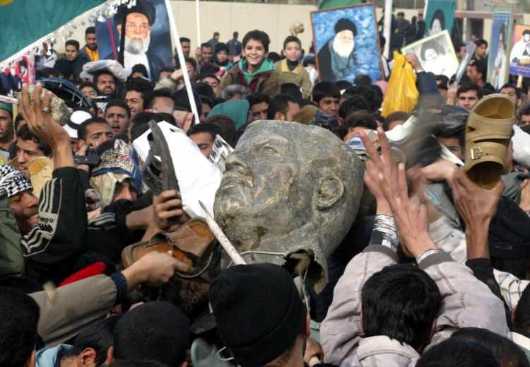 <p>Ülkenin tamamını ele geçiren koalisyon güçleri, 13 Aralık 2003'te Saddam'ı doğduğu Tikret'te yer altında gizlenirken yakaladı. Saddam'ın ailesiyle Baas rejiminden birçok üst düzey yetkili Ürdün'e kaçarak iltica etti. Hükümet ve ordunun tamamı lağvedildi.</p>
<p><br />
<br />
Fotoğraf: 17 Nisan 2003'de Irak'daki savaşın 29.günü. Saddam Hüseyin'in zarar görmüş bir heykeli görülüyor.</p>
