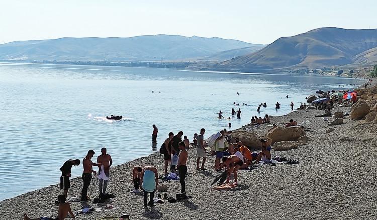<p>Van Gölü’ne güzel kıyıları bulunan Bitlis'in Tatvan, Ahlat ve Adilcevaz ilçelerine bayram tatillerini geçirmek için gelen vatandaşlar serinlemek için kendini Van Gölü'nün serin sularına bırakıyor. Hava sıcaklığının gün içerisinde 30 ile 35 derecelere kadar yükseldiği bölgede Van Gölü sahilleri bayram tatilinde serinlemek isteyenlerin akınına uğruyor. Akdeniz ve Ege sahillerinden farksız olan Van Gölü sahilleri, bayram tatiliyle birlikte çevre il ve ilçelerden gelen vatandaşlarla birlikte binlerce kişiyi ağırlıyor. </p>
