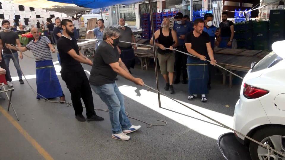 <p> Bir pazarcı forklift getirip aracı biraz havaya kaldırarak, ön lastiklerinin altına büyük plastik kapakları yerleştirdi. </p>
