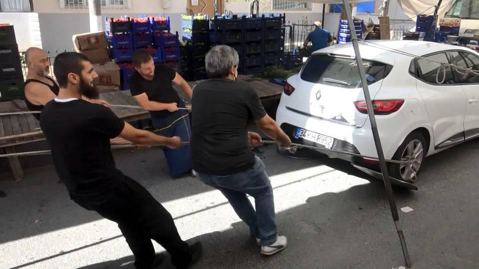 <p>Daha sonra arka lastiklerin jantlarına halatlar bağlandı. Pazarcılar, arka lastiklerinin altına metal tepsi, ön lastiklerinin altına da lastik kapaklar yerleştirdikleri aracı hemen yakındaki bir binanın otoparkına kadar çekip, iterek kaldırdı. </p>