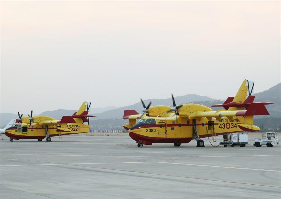 <p>Ardından havalanan helikopter ve uçaklar, alevlerin üzerine su boşaltıyor. Tekrar denizden, baraj ya da su göletlerinden su alan helikopterler zamanla yarışarak, alevleri durdurmaya çalışıyor.<br />
Gün içinde yakıt ikmali de yapan pilotlar, kuvvetli rüzgara rağmen yangınla mücadelesini sürdürüyor.<br />
 </p>
